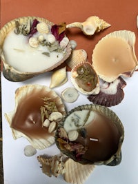 a group of candles with shells and seashells on a table